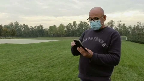 Close Up Portrait of Man Using a Smartphone While Wears a Medical Mask Stock Footage 141605930