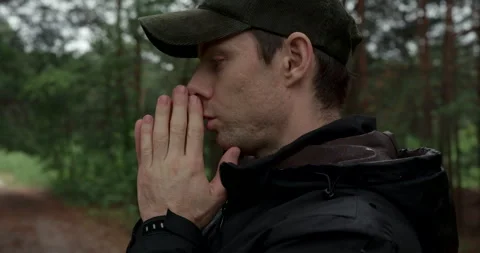 Close up portrait of man warming hands with his breath in autumn forest Stock Footage 340840388