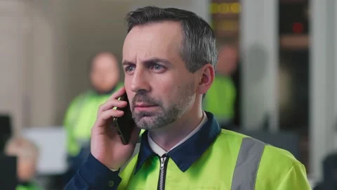 Close up portrait of mature engineer talking on phone in control room Stock Footage 197564112