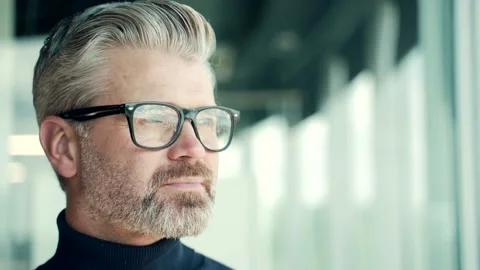 Close up portrait of a mature gray haired bearded businessman in glasses stand Stock Footage 232578604
