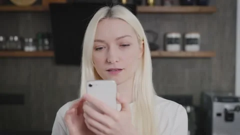 Close-up portrait of a middle-aged blonde woman looking into a smartphone Stock Footage 219205786
