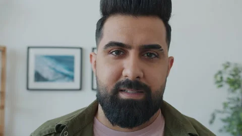 Close-up portrait of Middle Eastern man looking at camera with serious face then Stock Footage 153964705