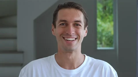 Close-up portrait of a millennial man in a white t-shirt looks at the camera and Stock-Footage 239508864