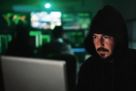 Close up portrait of one hacker looking the screen of a laptop computer, typing Stock Photos