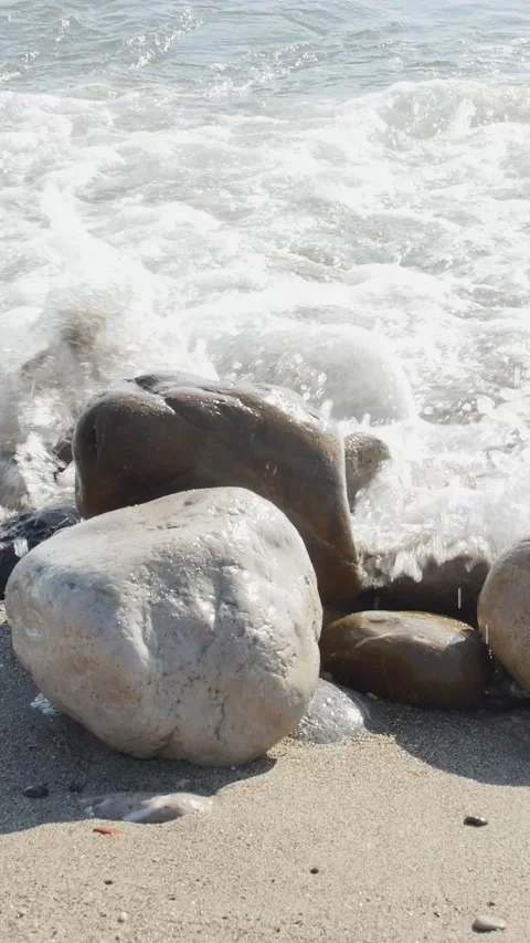 Close-up portrait orientation of clear ocean water flowing over coastal ston Video stock 334627704