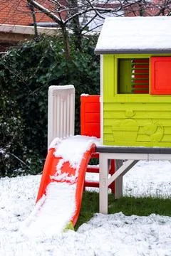 A close up portrait of a part of a tiny green play house with a red slide s.. Stock Photos