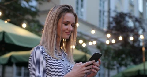 A close-up portrait of a pretty lady typing on her phone and suddenly turning Stock Footage 104614244