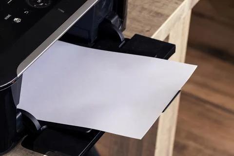 A close up portrait of a printer with an empty white piece of paper in its pr Stock Photos