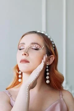 Close-up portrait of a red-haired and pale-skinned woman with closed eyes and Stock Photos