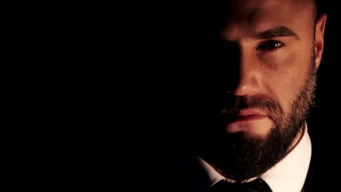 A close-up portrait of a rugged, bearded man in a white shirt and suit. Stock Footage 318569419