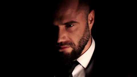 A close-up portrait of a rugged, bearded man in a white shirt and suit. Video stock 318569497