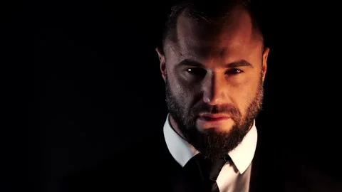 A close-up portrait of a rugged, bearded man in a white shirt and suit. Stock Footage 318569626