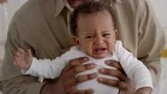 Close Up Portrait Of Sad African American Baby Boy Crying In Fathers Hands Stock Footage