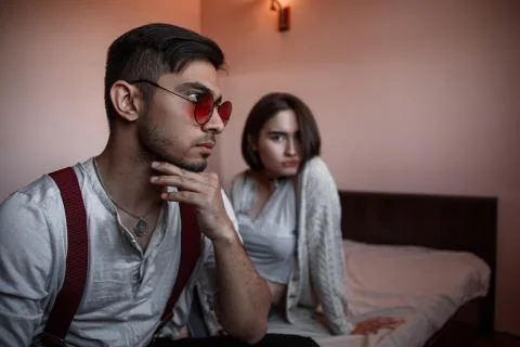 Close-up portrait of a sad brooding brunette guy in sunglasses. in the backgr Stock Photos