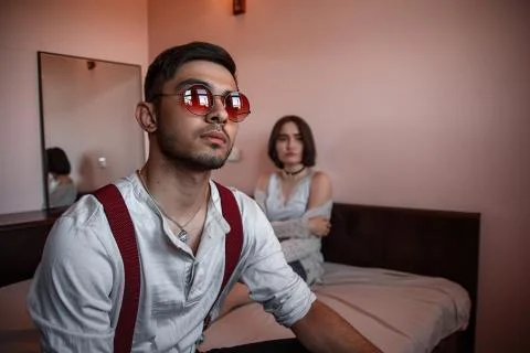 Close-up portrait of a sad brooding brunette guy in sunglasses. in the backgr Stock Photos