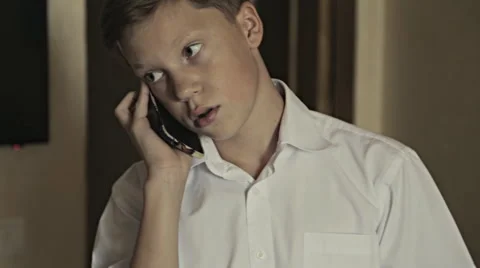 Close-up portrait of a schoolboy talking over telephone Stock Footage 67717758