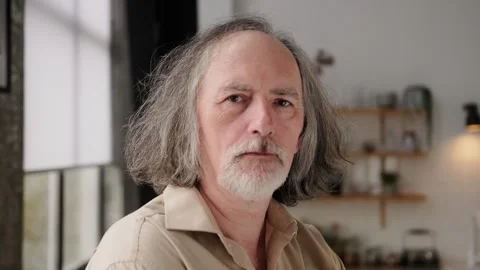 Close-up portrait of a serious elderly gray-haired man looking at the camera Stock Footage 262240923