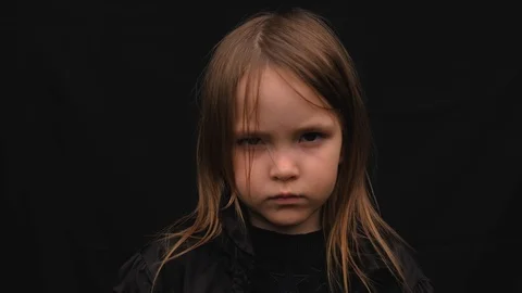 Close-up portrait of a serious sad cute little girl in black clothes Stock Footage