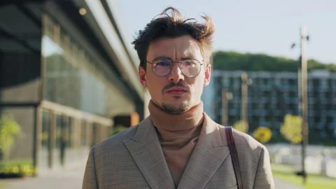 Close up portrait serious young man with glasses looking at the camera sad Stock Footage 252142185