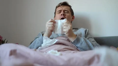 Close-up portrait of sick young man sneezing. sick and illness concept Stock Footage 262838286