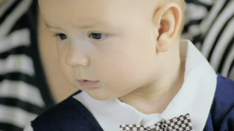 Close-up portrait of a six-month boy in a suit near his mom at home. SLOW MOTION Stock Footage 102824986