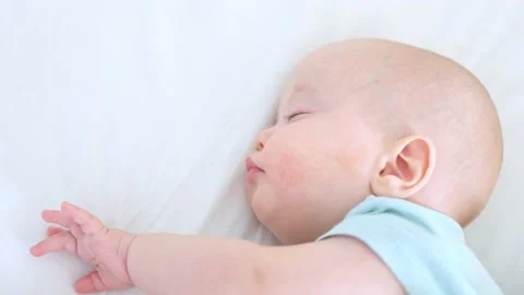 Close-up portrait of sleeping infant three months baby in white bed waking up Stock Footage 179164554