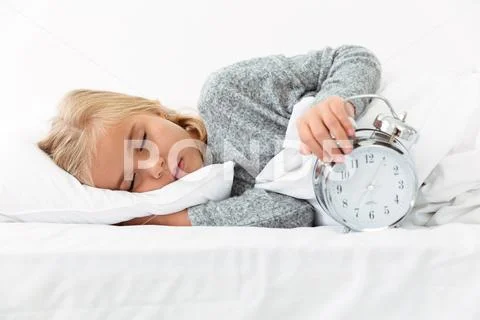 Close-up portrait of sleeping kid holding alarm clock Stock Photos