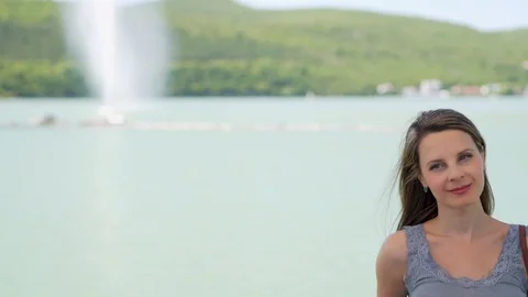 Close-up portrait of a slender long-haired woman at a beautiful lake, camera sli Video stock 116538485