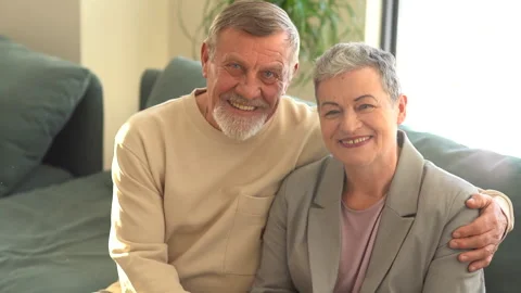 Close portrait of smiling elderly husband and wife looking at camera. A woman Stock Footage 169605488