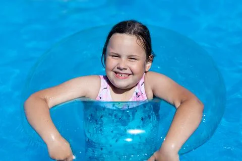 Close-up portrait of a smiling five-year-old girl lying on the surface of the Stock Photos