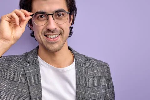 Close-up portrait of smiling guy in suit wearing spectacles isolated on purple Stock Photos