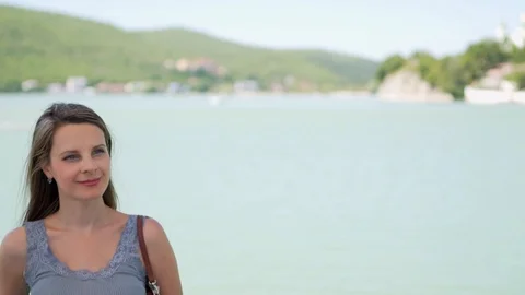  Close-up portrait of a smiling long-haired attractive woman at a beautiful lake Stock-Footage 116540141