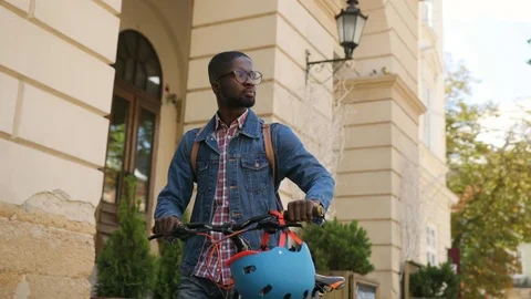Close up portrait of smiling young african man walking on the city with bicycle Stock Footage