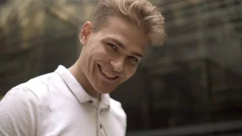 Close-up portrait of a smiling young blue-eyed blond man looking at the camera Stock Footage 114453746