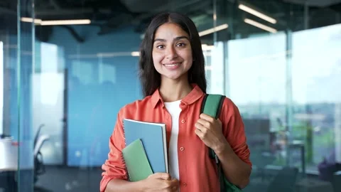 Close-up portrait of smiling young female student with backpack holding books  Stock Footage 345736334