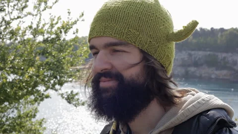 Close-up portrait of a smiling young man with a black beard in a knitted hat. Stock-Footage 113791309