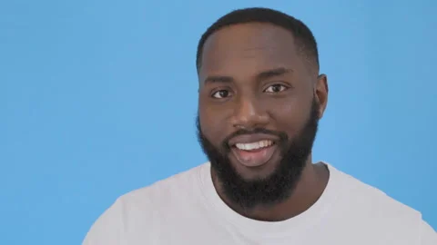 Close up portrait of a smiling young man in t-shirt looking at camera and Video stock 117741757