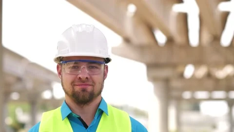 Close up portrait of smiling young master builder in protective white hard hat Stock Footage 200389326