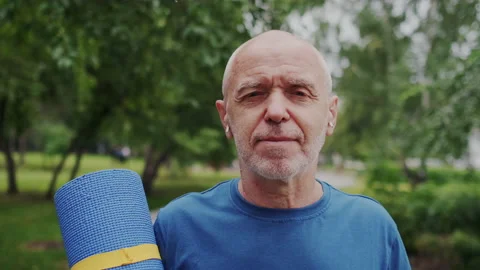 Close-up Portrait of Strong Old Man with Age Wrinkles. He Standing in Park with Stock Footage 148464202