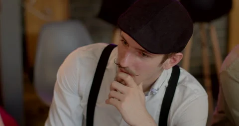 Close portrait of thoughtful man with mustache in cap and suspenders. surprise Stock Footage 248864310