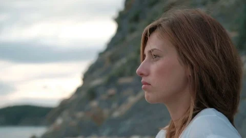 Close-up portrait of thoughtful red-haired woman near rocks evening. Stock Footage 80267596