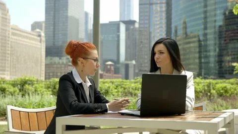 Close-up portrait of two beautiful concentrated business women talking at the Stock Footage 155946339