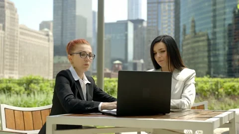 Close-up portrait of two beautiful concentrated business women talking at the Video stock 155946365