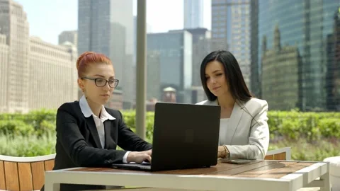 Close-up portrait of two beautiful concentrated business women talking at the Stock Footage 155946382
