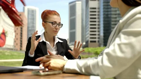 Close-up portrait of two beautiful concentrated business women talking at the Stock Footage 155946479