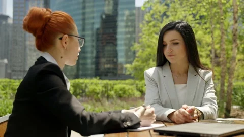 Close-up portrait of two beautiful concentrated business women talking at the Stock Footage 155946552