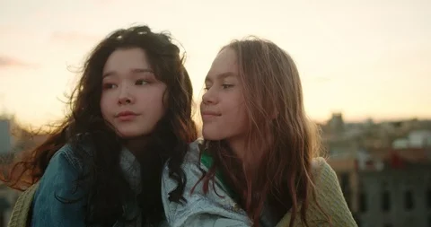 Close up portrait of two charming pensive young girls enjoying city view at Stock Footage 125307692