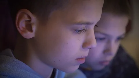 Close Up Portrait view of two brothers who are intensely looking at the screen Stock Footage 101028845