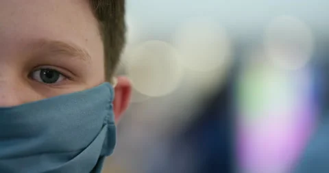 Close-up portrait view of a young boy wearing a protective facemask Stock Footage 134698094