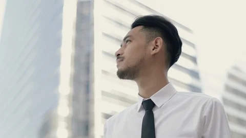 Close up portrait of young asian businessman thinking about future business. Stock Footage
